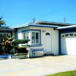 A suburban house with a garage and driveway under a clear blue sky.