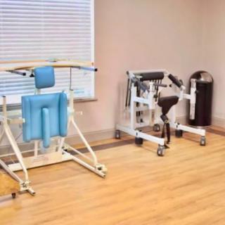 A room equipped with rehabilitation and exercise machines for physical therapy.