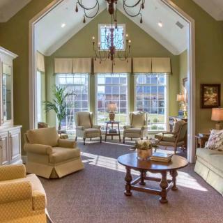 A spacious and elegantly furnished living room with large windows allowing in natural light.