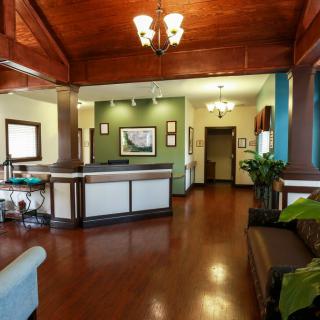 A modern office lobby with wooden floors and elegant lighting.