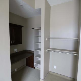 A minimalist closet interior featuring open shelves and hanging rods for storage.