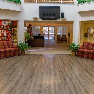 A spacious lobby area with sofas, plants, and a television mounted on the wall.
