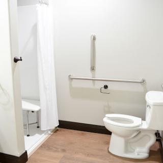 A clean and accessible bathroom featuring a toilet and shower area.