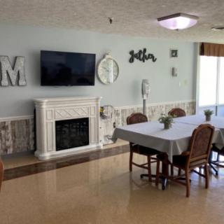 A cozy living and dining area with a fireplace, television, and elegantly set table.