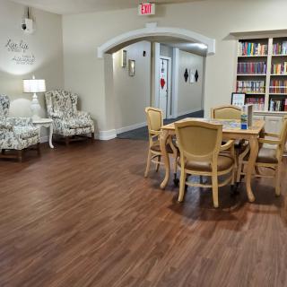 Comfortable reading and seating area with bookshelves and wooden flooring.