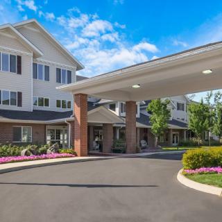 Entrance to a well-maintained retirement home with a landscaped driveway.