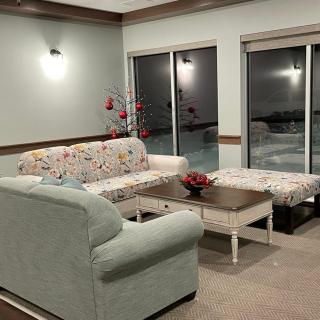 A cozy living room with a floral-patterned sofa and sliding glass doors.