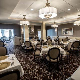 A sophisticated dining room with elegant chandeliers and neatly arranged tables.