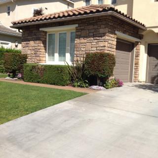 A suburban house with a neatly maintained lawn and a brick exterior.