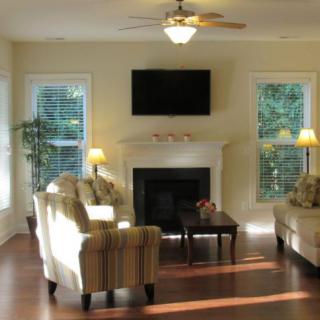 A cozy living room with sofas, a fireplace, and a wall-mounted TV.