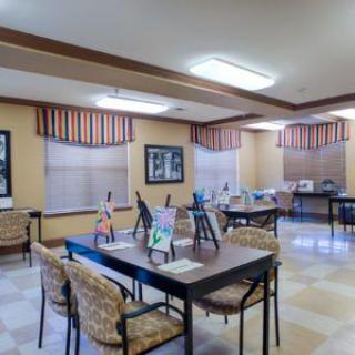 A well-lit activity room with tables set up for art projects.