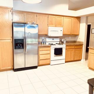 A spacious kitchen featuring wooden cabinets and modern stainless steel appliances.