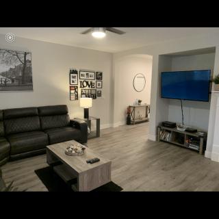 A modern living room featuring a comfortable sofa, wall-mounted TV, and a stylish coffee table.