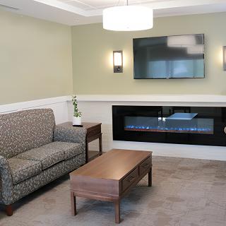 A modern living room with a sofa, coffee table, fireplace, and TV.