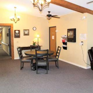 A cozy dining area with a table and chairs, decorated with chandeliers and wall art.