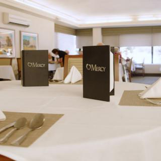 A neatly set dining table in a restaurant with menus placed upright.