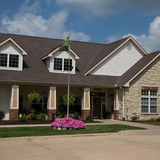 A charming suburban house with a well-maintained lawn and colorful flowers in the front yard.