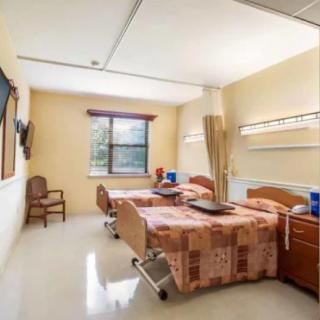 A hospital room with two beds and a window.