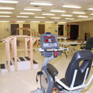 A physical therapy room equipped with exercise equipment and rehabilitation tools.