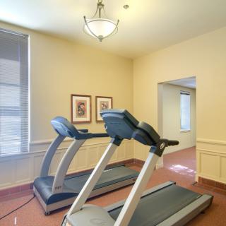 A small gym with two treadmills placed side by side.