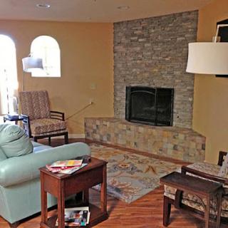 A cozy living room featuring a stone fireplace and comfortable seating.