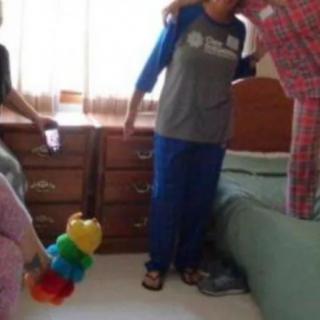 A group of people standing in a bedroom with toys and casual attire.