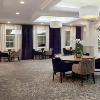 A modern dining area with elegant tables, upholstered chairs, and stylish lighting.
