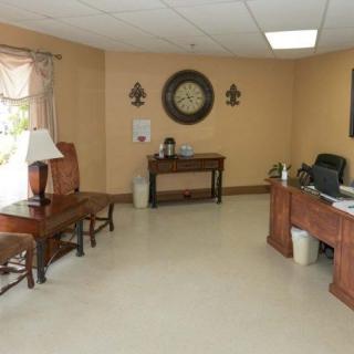 An office reception area with a desk, chairs, and wall decorations.