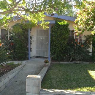A cozy house with a lush front yard and a pathway leading to the door.