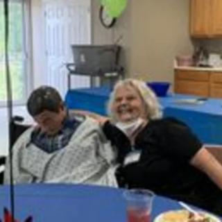 Two people sitting at a table during a casual social gathering.