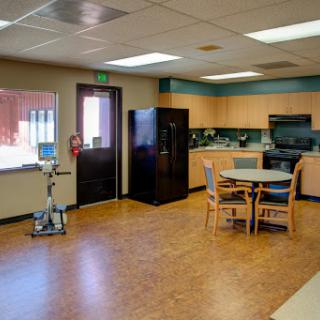 A well-lit kitchen and dining area featuring a table and chairs, refrigerator, and cabinets.