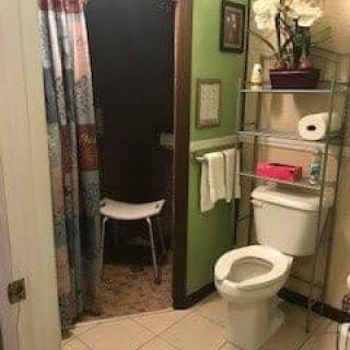 A cozy bathroom with a shower and storage shelves.