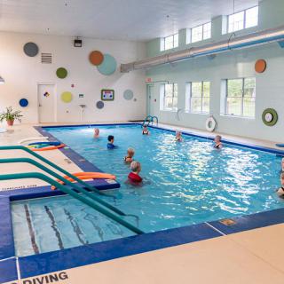 Children enjoy swimming and playing in an indoor pool.