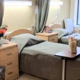 A hospital room with two beds and medical equipment.