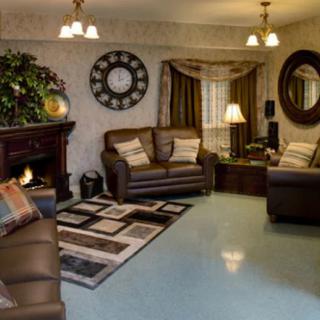 A cozy living room featuring leather sofas, a fireplace, and elegant decor.