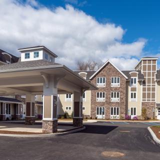 Modern residential building with a covered entrance and clear sky.