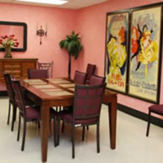 A dining room with a wooden table, surrounded by chairs and decorated with artwork on the walls.