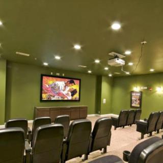 A well-equipped home theater room with multiple rows of plush seating and a large screen.