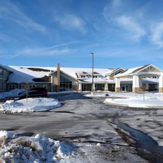 A winter view of a building covered in snow under a clear blue sky.