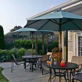 A cozy outdoor patio with tables and umbrellas, perfect for a summer day.