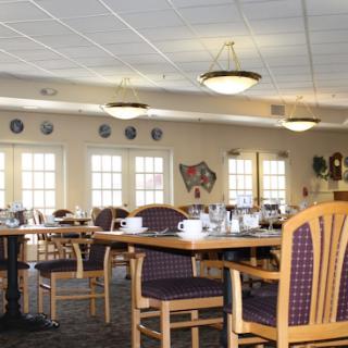 A spacious dining area set up with tables and chairs, ready for guests.