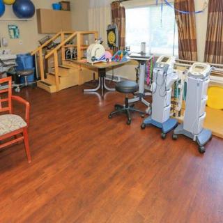 A therapy room equipped with various medical and exercise equipment for rehabilitation.