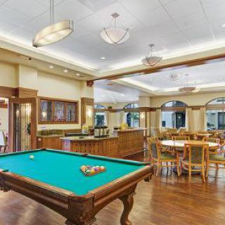 A stylish game room featuring a billiards table and elegant wooden furnishings.