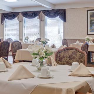 A beautifully arranged dining area with elegantly set tables and floral centerpieces.