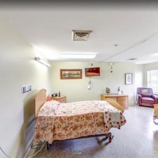 A cozy hospital room with a neatly made bed and comfortable furnishings.