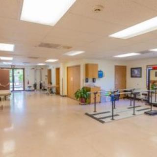 A spacious and well-lit rehabilitation center with parallel bars for therapy exercises.
