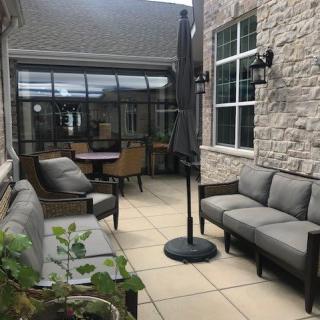A cozy outdoor patio area with comfortable seating and a large umbrella.