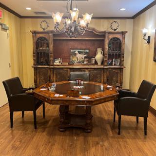 A cozy conference room featuring an octagonal wooden table and elegant seating, complemented by a chandelier.