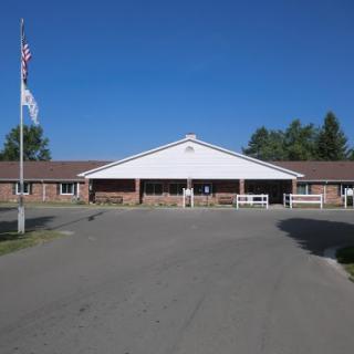 A well-maintained school building set against a clear blue sky.