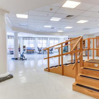 An inviting physical therapy space equipped with stairs and various exercise equipment for rehabilitation.